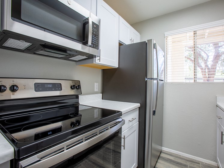 Renovated apartment kitchen in Tucson with stainless steel energy appliances at The Vintage on Speedway Blvd